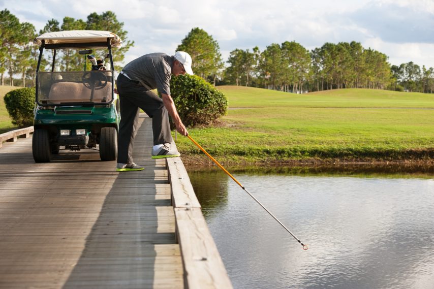 retreiving golf ball from water hazard Getty Images/iStockphoto
